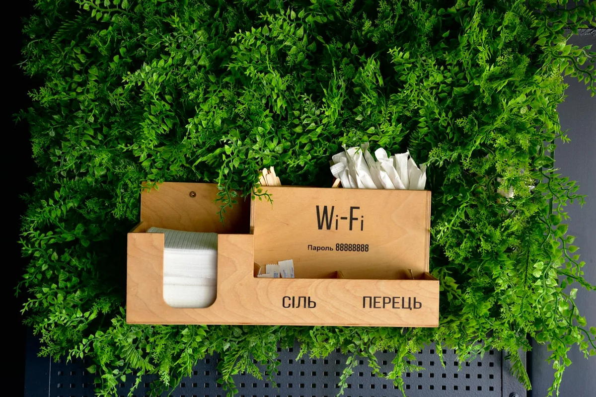 Wooden box on green background with Wi-Fi details and storage compartments.
