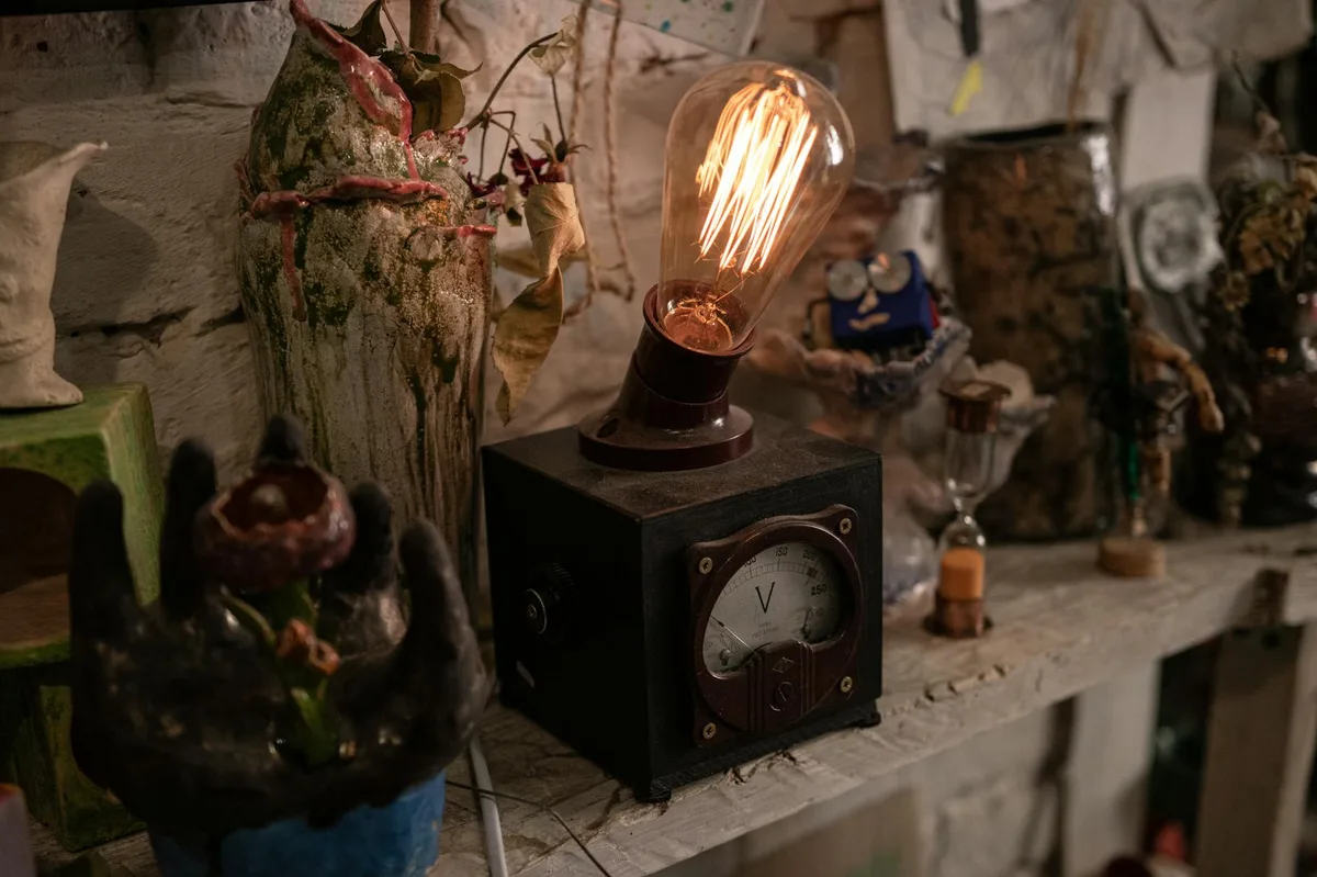 A creative display of vintage decor featuring an Edison bulb in a cozy Lviv cafe ambiance.